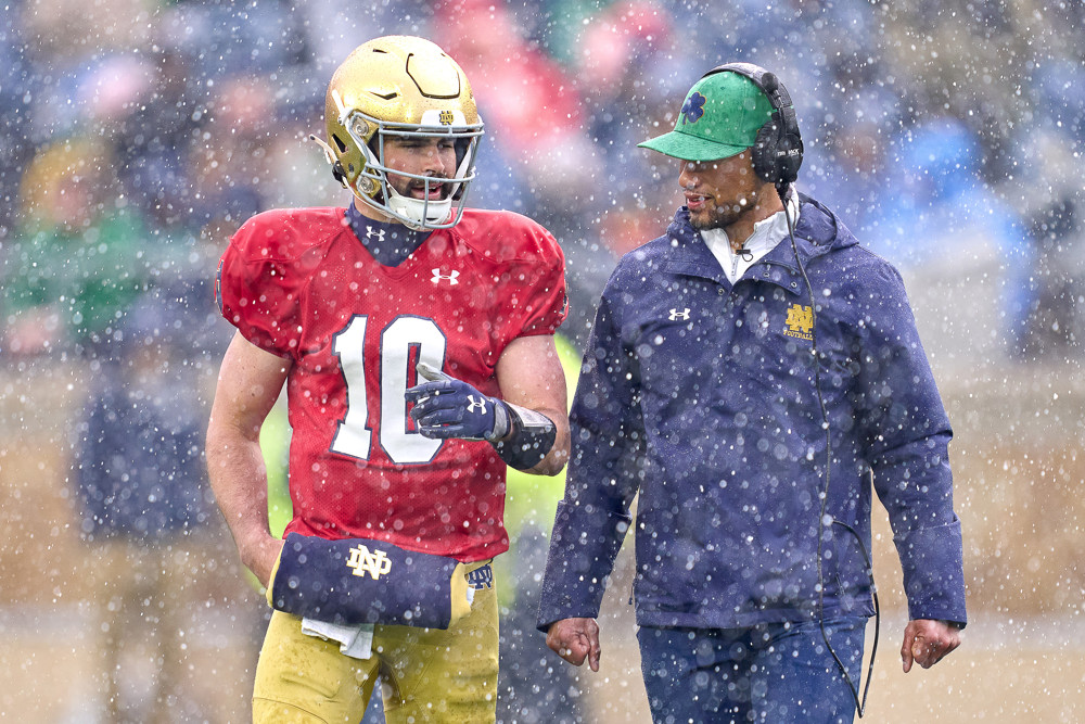 Notre Dame quarterback Joe Montana runs out of the arms of